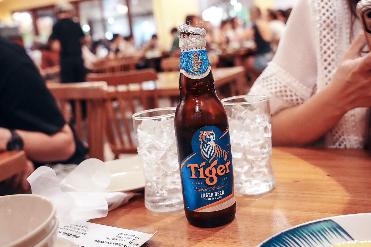 峴港 BepCuon 餐桌上的 Tiger 啤酒瓶與兩杯裝滿冰塊的玻璃杯