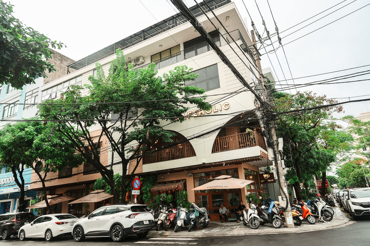 從街道側面拍攝 Cafeholic Coffee 建築與門前綠樹