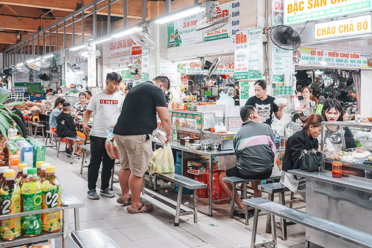 峴港共市場周邊餐飲區，攤商與客人在桌椅之間活動