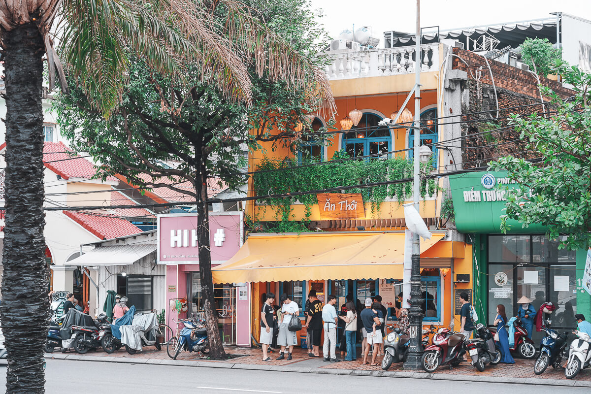 峴港 Bạch Đằng 路上 Ăn Thôi 餐廳橘色外觀與門口排隊人潮