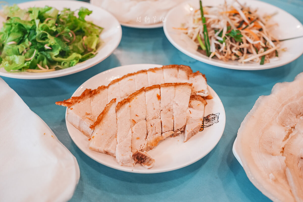 峴港 DONALD TRUNG 白盤盛裝的脆皮燒肉切片，旁邊是水煮豬肉、生菜與配料