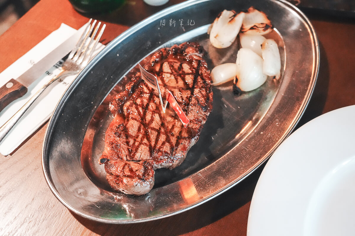 Olivia's Prime Steakhouse 不鏽鋼盤上的格紋烤痕牛排與烤洋蔥