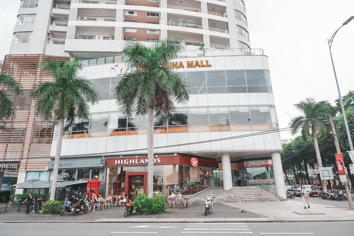 從街道拍攝峴港 Indochina Mall 大樓外觀，一樓有 Highlands Coffee 與 Texas Chicken