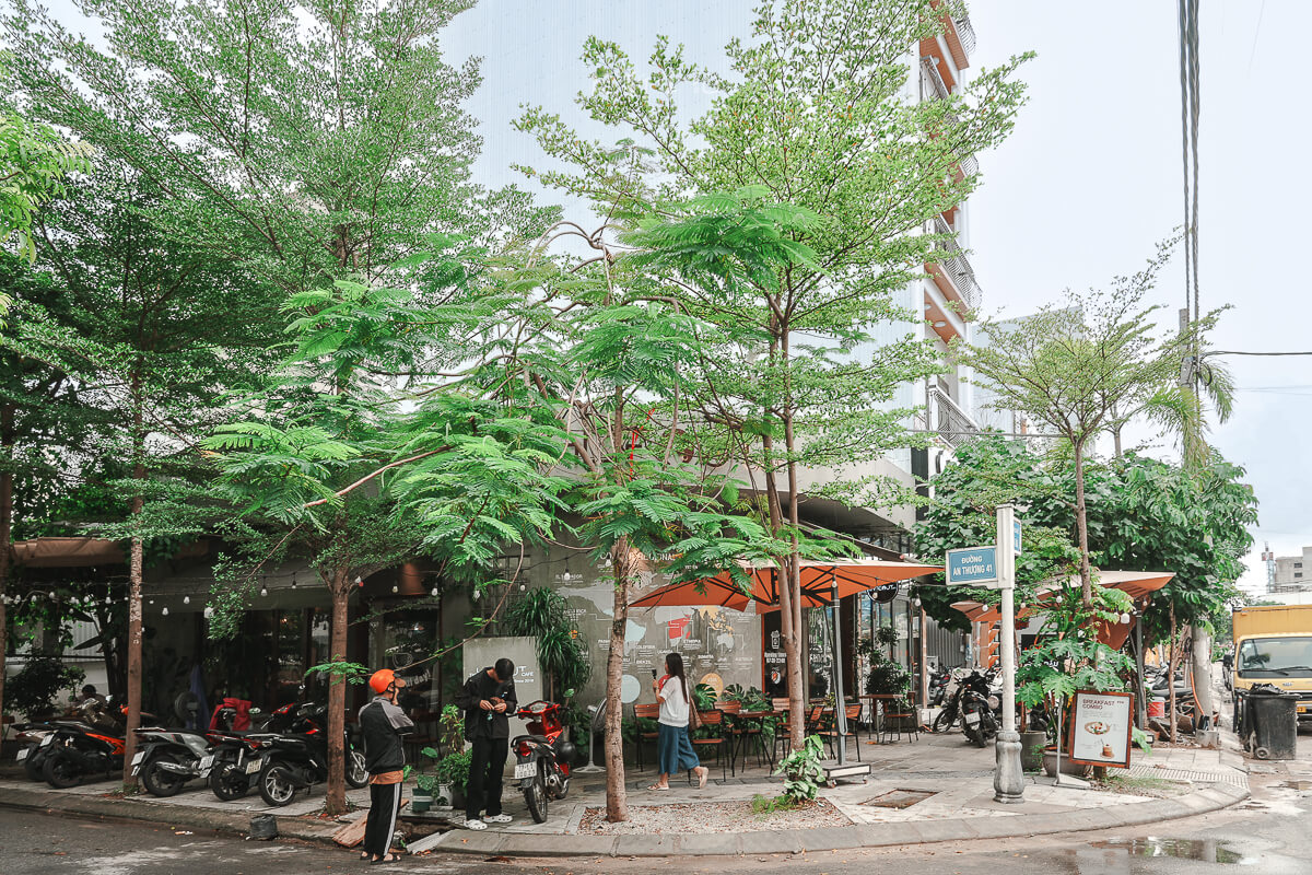 峴港 The Hideout Cafe 街邊店面，門前有綠樹與戶外座位