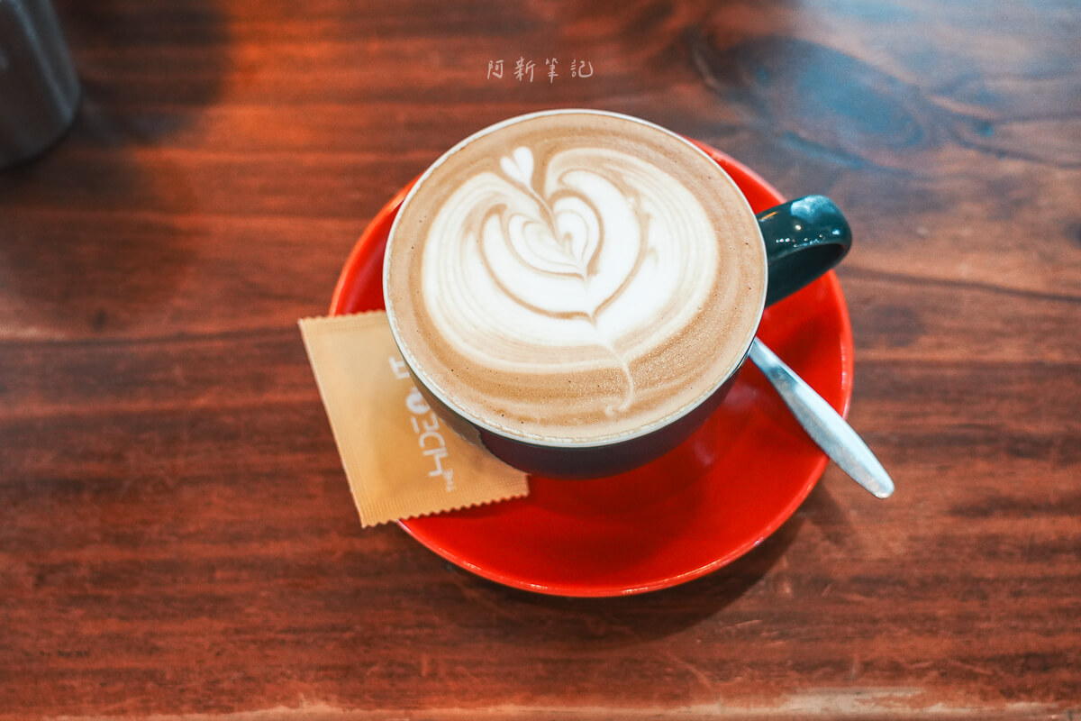 峴港 The Hideout Cafe 紅色杯盤上的熱咖啡，表面有拉花
