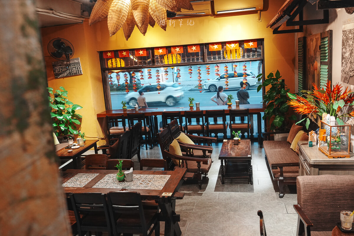 峴港 Ut Tich Cafe 店內黃色牆面、竹編吊燈與窗邊面街座位